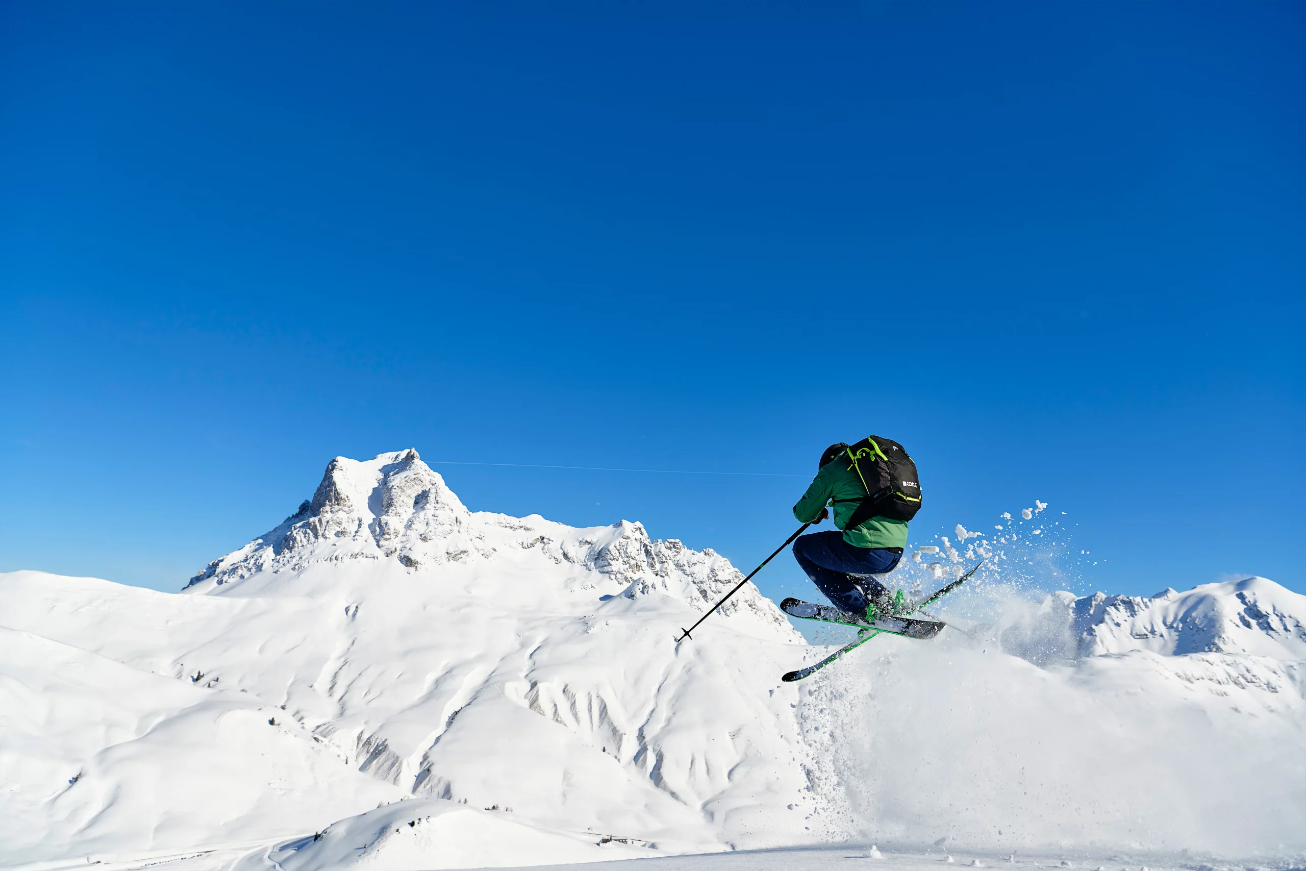 Salto de esquiador en nieve primavera
