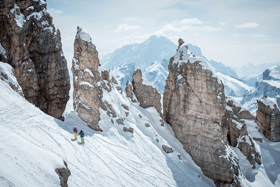Dos esquiadores ascendiendo una montaña nevada