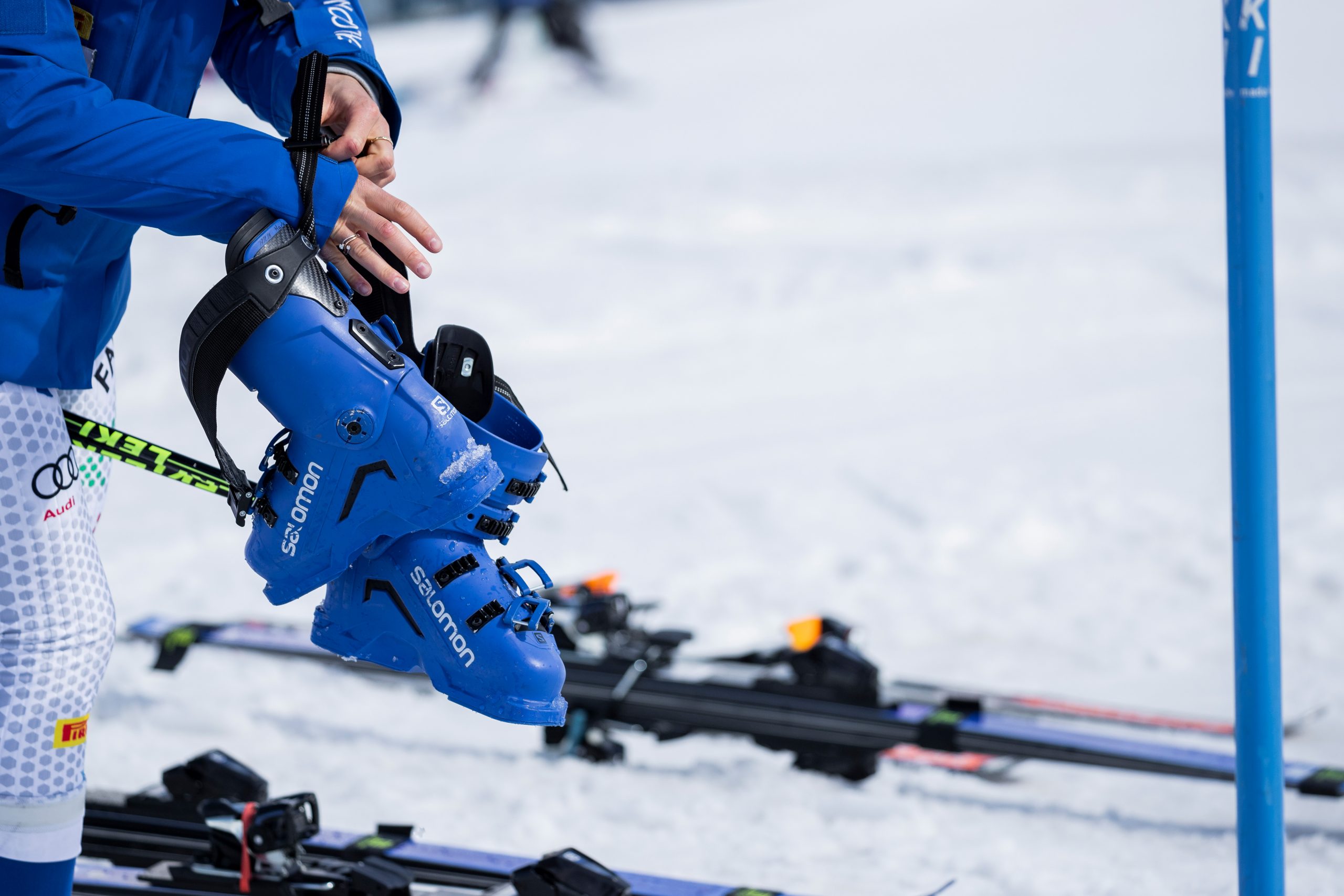 Mujer guardando sus botas de Esquí Alpino Salomon azules
