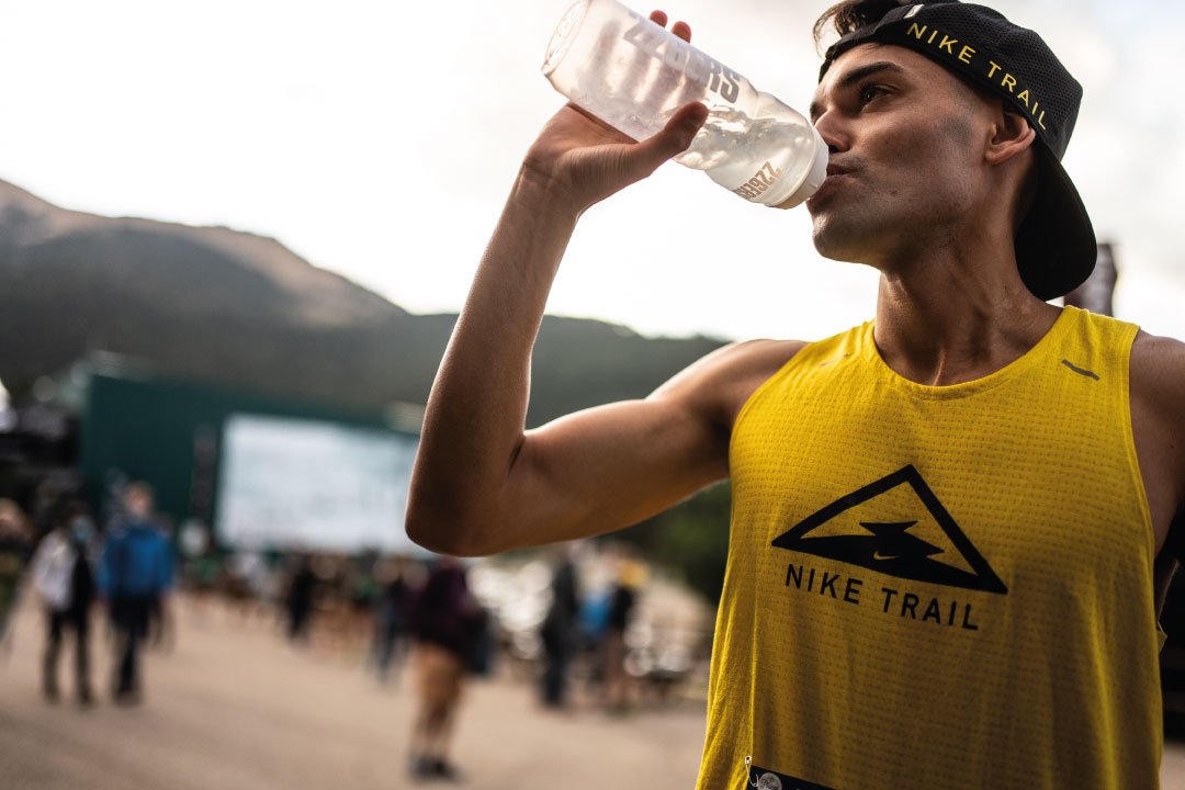 Corredor de Trail Running hidratándose para evitar los efectos del calor