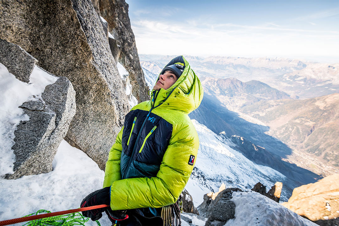 Alpinista con chaqueta Millet asegurando a otro alpinista