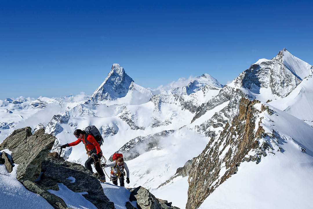Dos alpinistas ascendiendo una montaña