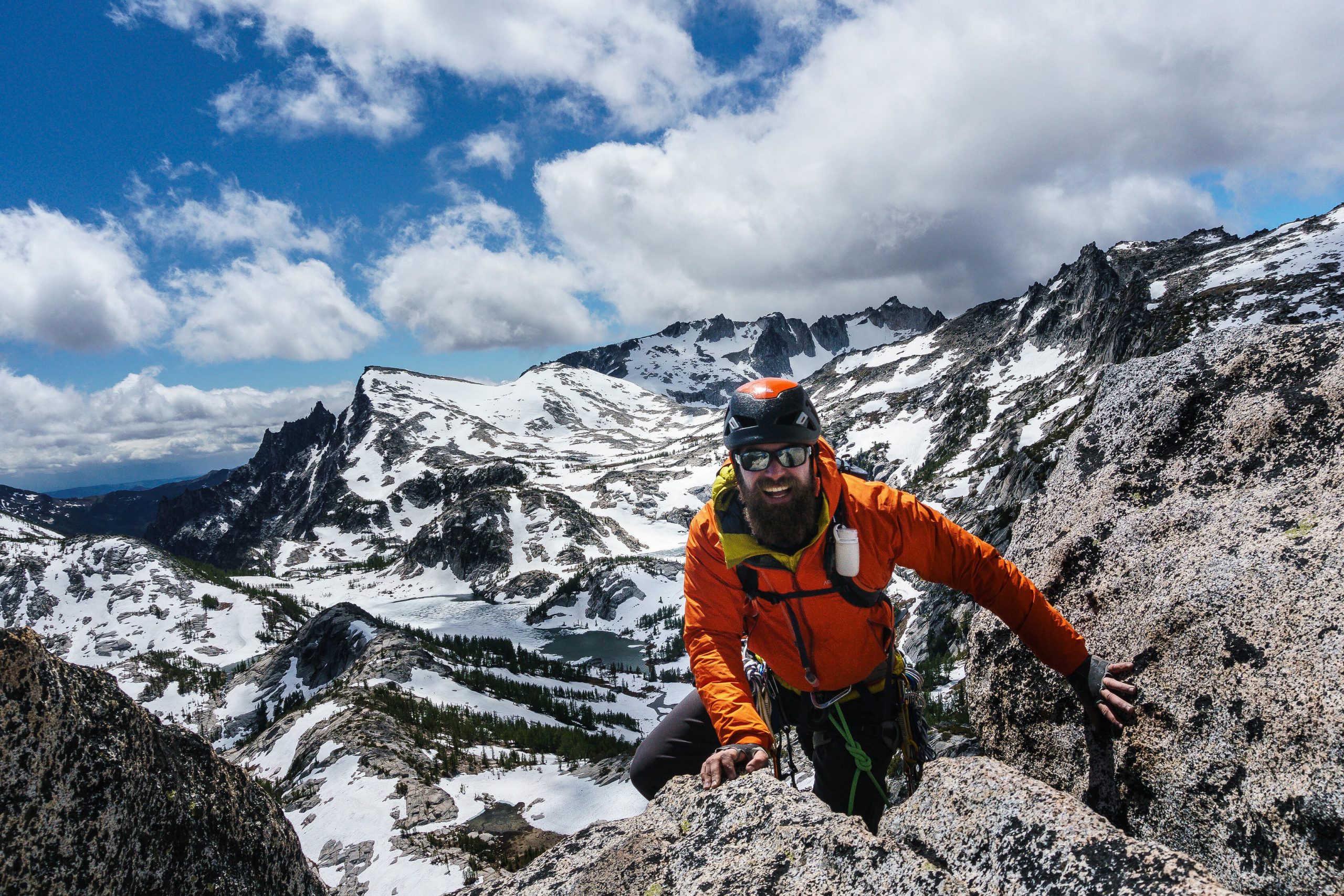 Alpinista en la cima de la montaña nevada sonriendo